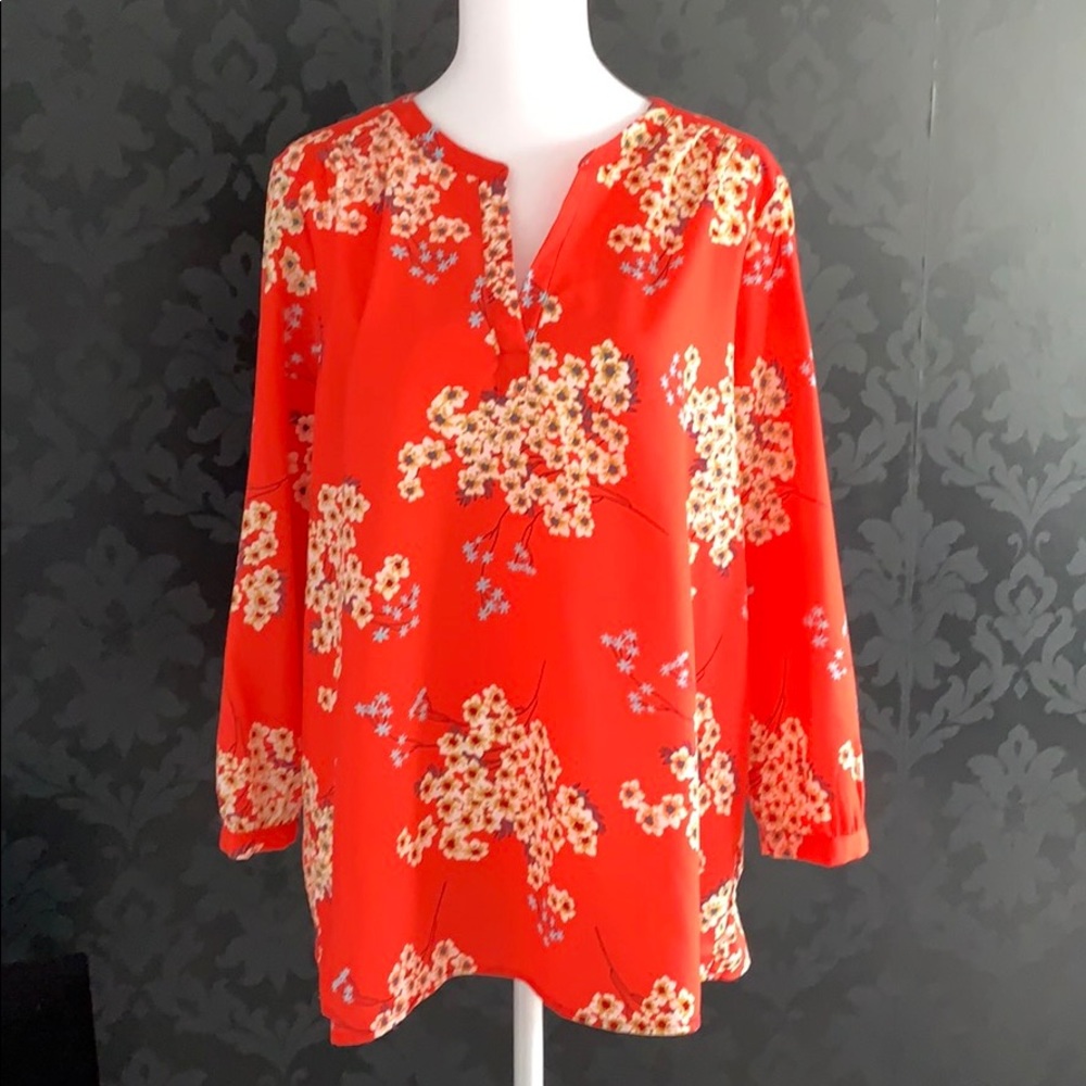 Tomato-red blouse with floral detail.